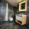 Interior of modern stylish bathroom with black tiled walls, curtain shower place and wooden