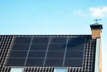 Newly build houses with solar panels attached on the roof against a sunny sky