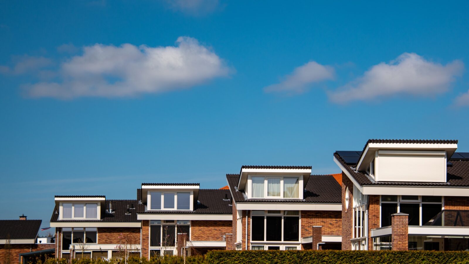 Newly build houses with solar panels attached on the roof against a sunny sky