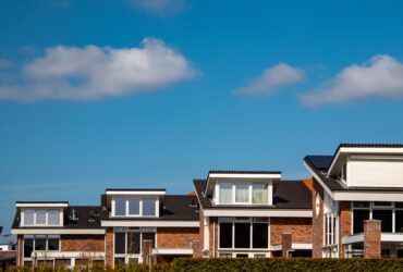Newly build houses with solar panels attached on the roof against a sunny sky