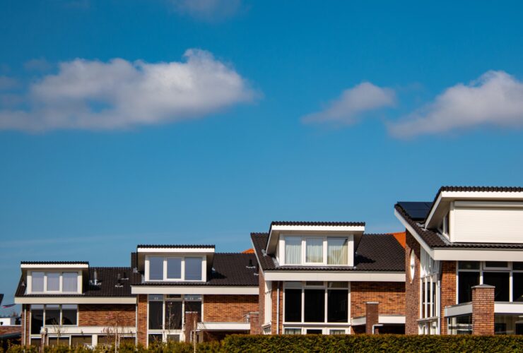 Newly build houses with solar panels attached on the roof against a sunny sky