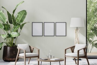 poster frames in room interior with light neutral wall with sunlight and wooden furniture