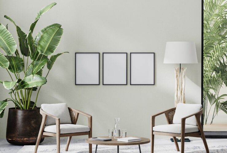poster frames in room interior with light neutral wall with sunlight and wooden furniture
