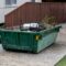 Skip bin full of household waste rubbish. House clean up and renovation concept. Waste management