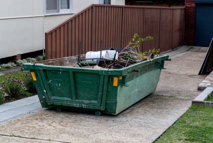 Skip bin full of household waste rubbish. House clean up and renovation concept. Waste management