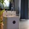 Air purifier with digital monitor screen and house plant in living room for fresh air.