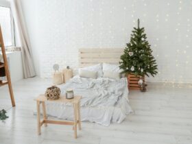 Christmas tree in bed room. Light interior.