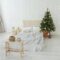 Christmas tree in bed room. Light interior.