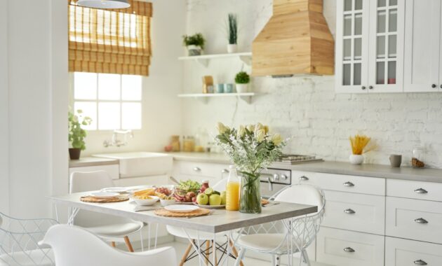 Cozy kitchen. Modern bright white kitchen interior with wooden and white details. Vase with flowers