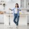 Happy woman showing thumbs up cleaning floor with spray mop