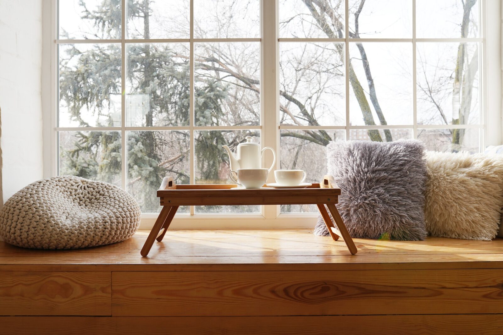 Large window with a window sill with hot tea and cups. The concept of rest and relaxation