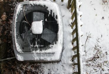 Overhead view of Central Air Conditioner HVAC unit covered with snow after snowstorm