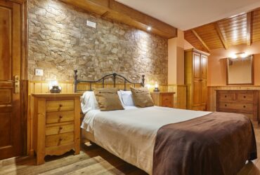 Rustic style bedroom indoor. Wood and stone decoration. Nobody