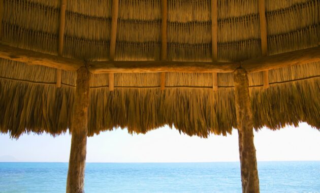 A typical thatched roof cabana on an ocean beach in the caribbean