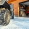 Back POVview of quad bike offroad vehicle parked front house garage door on snowy cold winter day.