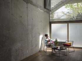 Businesswoman sitting in a loft at concrete wall having a break