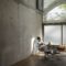 Businesswoman sitting in a loft at concrete wall having a break