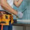 Expert. Cropped shot of young repairman, professional plumber holding a screwdriver while fixing a