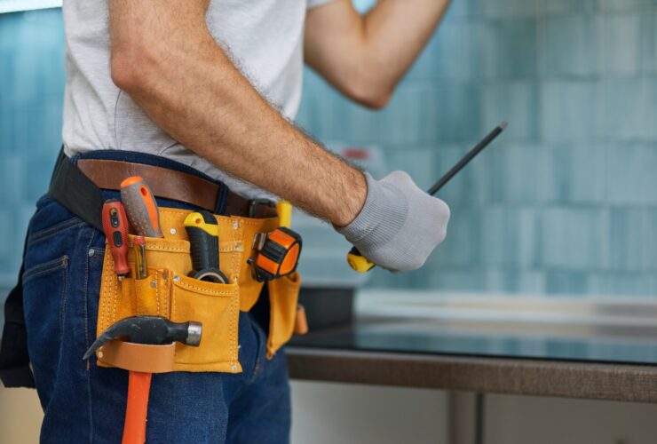 Expert. Cropped shot of young repairman, professional plumber holding a screwdriver while fixing a