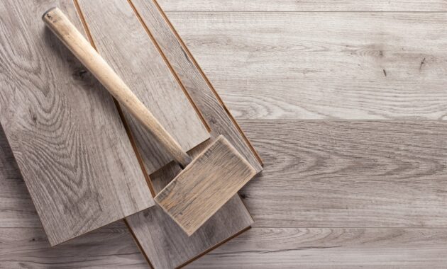 Laminate wood floor and wooden hammer tool. Laminate flooring