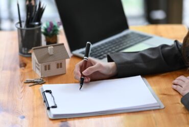 Real estate agent woman analyzing real estate investment data on wooden table.