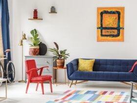 Red chair and royal blue lounge placed in bright sitting room in