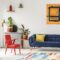 Red chair and royal blue lounge placed in bright sitting room in