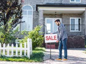 young man with sale board selling his new house