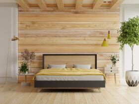 Bedroom interior mockup with gray bed on empty wooden wall background.