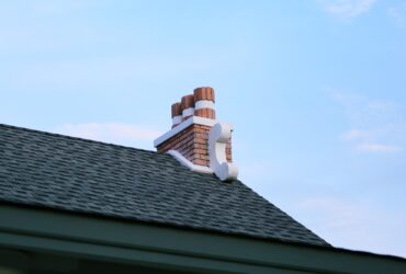 Chimney on house roof closeup blue sky background