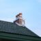 Chimney on house roof closeup blue sky background