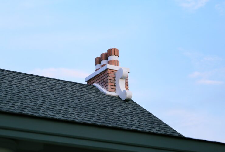Chimney on house roof closeup blue sky background