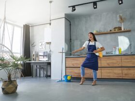 Love the things you do. Full length shot of cheerful young woman, cleaning lady pretending to play