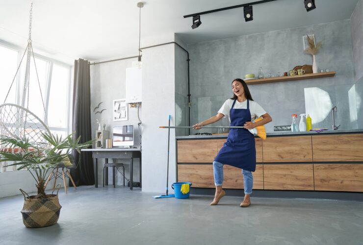 Love the things you do. Full length shot of cheerful young woman, cleaning lady pretending to play