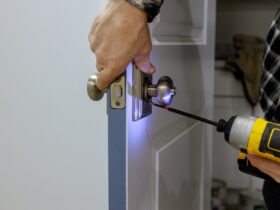 Maintenance in the apartment woodworker hands is installing the doors handle