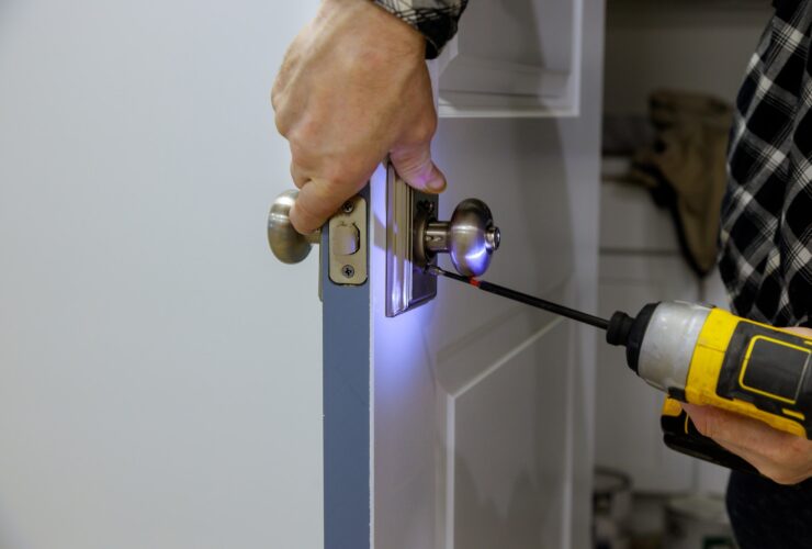 Maintenance in the apartment woodworker hands is installing the doors handle