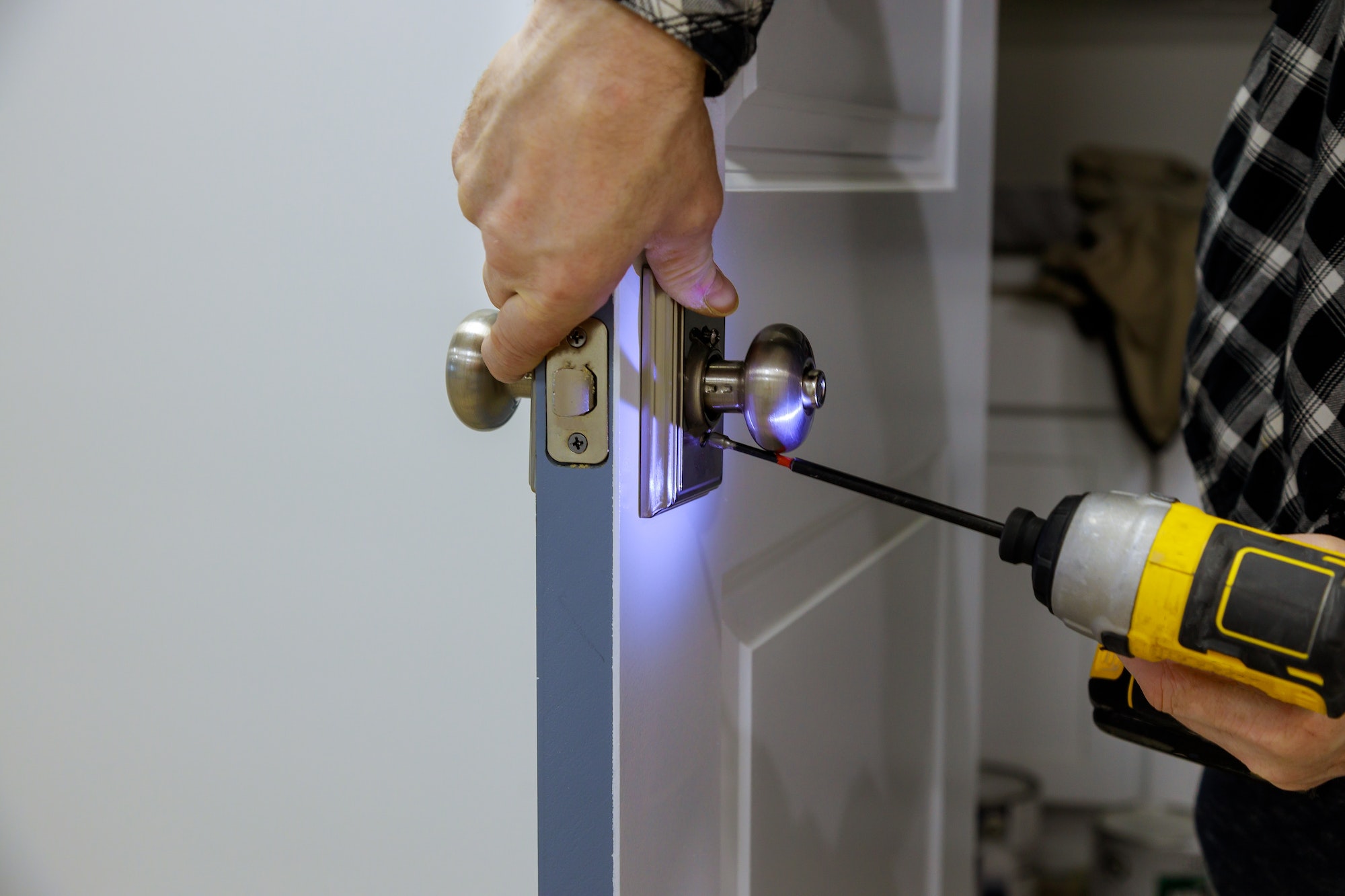 Maintenance in the apartment woodworker hands is installing the doors handle