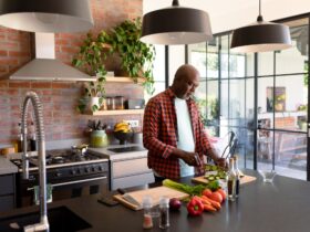 Serious african american senior man cooking in kitchen