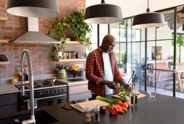 Serious african american senior man cooking in kitchen