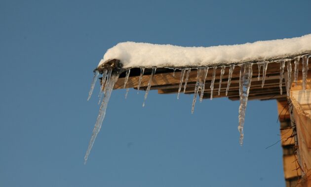 Winter time. Icicles on a roof