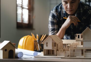 Engineer architect designer freelance work on start-up project with home model, construction plan