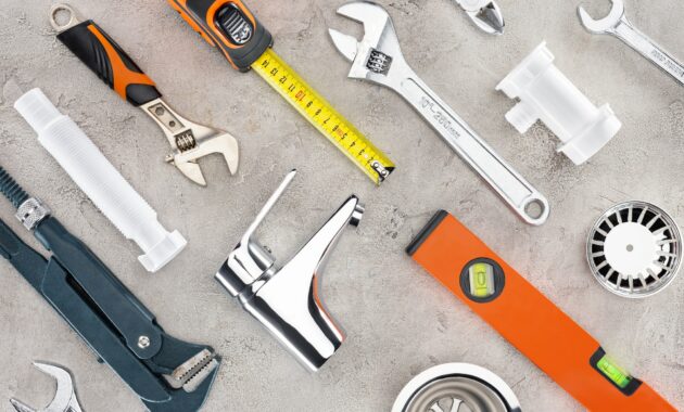 flat lay with various plumbing tools on concrete surface