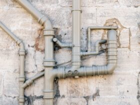 Iron sewer pipes on stone wall background