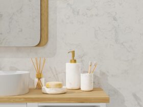 Modern bathroom interior with vessel sink, diffusers, soap, toothbrush, shampoo on wooden countertop