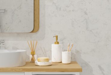 Modern bathroom interior with vessel sink, diffusers, soap, toothbrush, shampoo on wooden countertop