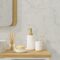 Modern bathroom interior with vessel sink, diffusers, soap, toothbrush, shampoo on wooden countertop