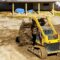 Bulldozer moving, leveling ground at construction site in ground using shovels