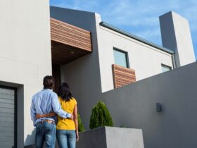 Happy Hispanic couple standing and looking at the new house