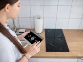 Housewife turning on the cooktop using a gadget