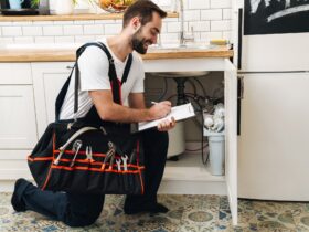 Image of plumber man with equipment and clipboard working in apartment